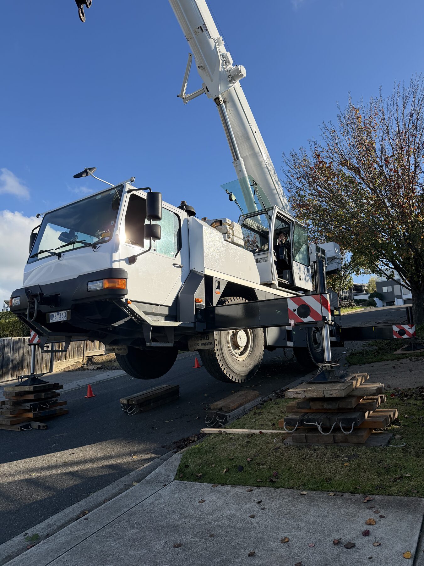 Crane set up on outriggers in a residential street